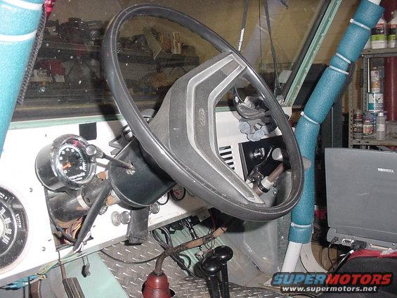1969 Ford Bronco interior showing steering wheel, dashboard gauges, and shifter