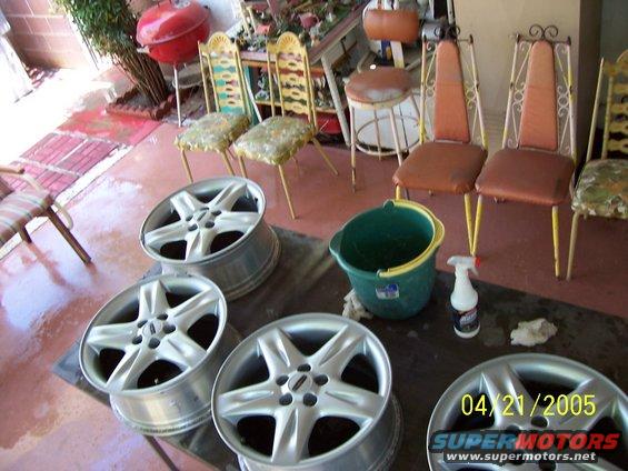 Four silver alloy wheels with five spokes each, some with a black center cap