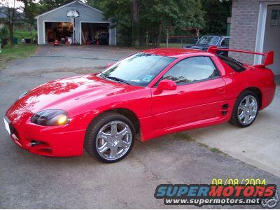 red 1999 Mitsubishi 3000GT parked in driveway with garage in background