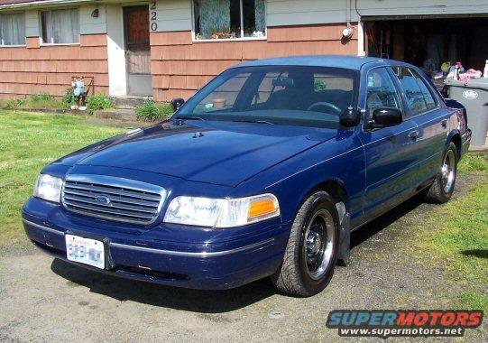 Blue 1998 Ford Crown Victoria with chrome grille, parked outside a house