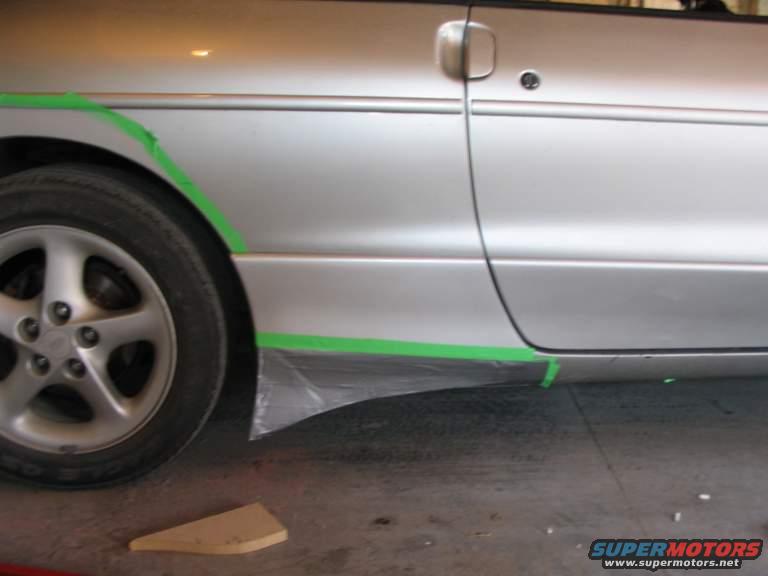 1993 Ford Probe side panel with green masking tape around the lower body and wheel well