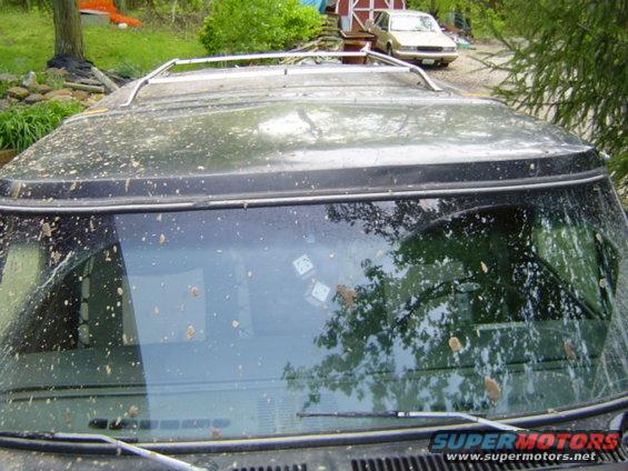 Black SUV with mud splatters on windshield and roof, dice visible inside