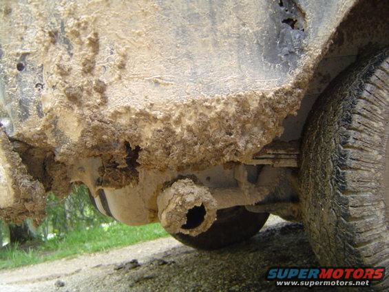 Mud-caked undercarriage and tire of a vehicle