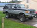 1989 Ford Bronco - This lifted Ford Bronco has a two-tone paint scheme and aftermarket wheels, indicating a modified suspension system.