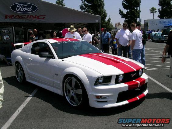 White Ford Mustang with red racing stripes, GT badging visible