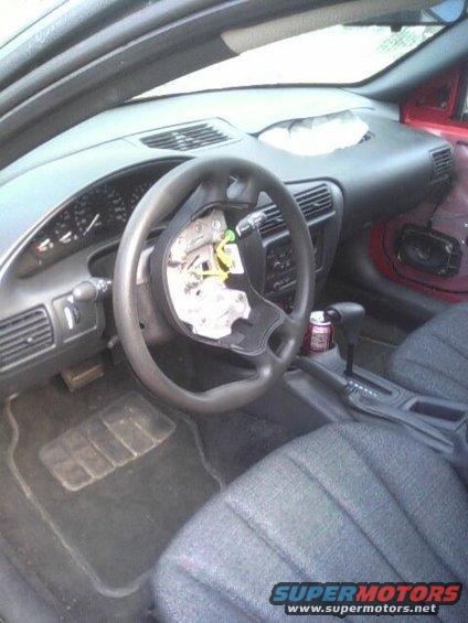 Interior of a car with the steering wheel removed, showing the dashboard and seats