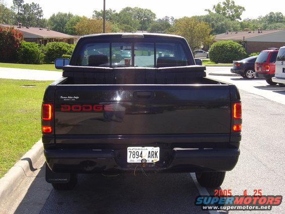 Rear view of a black 1997 Dodge Power Ram pickup truck with a toolbox in the bed