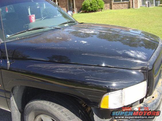 1997 Dodge Power Ram hood with numerous scratches and paint damage