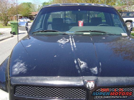 Black 1997 Dodge Power Ram truck with peeling paint on the hood, front view