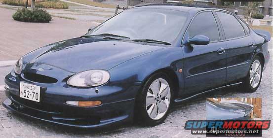 Dark blue sedan with aftermarket wheels and body kit. Has a Japanese license plate