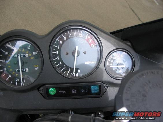 Motorcycle dashboard with speedometer, tachometer, and fuel gauge. Shows 08225 miles and 2792 hours