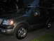 1997 Ford Expedition - Dark SUV parked in a driveway at night with another vehicle in the background.