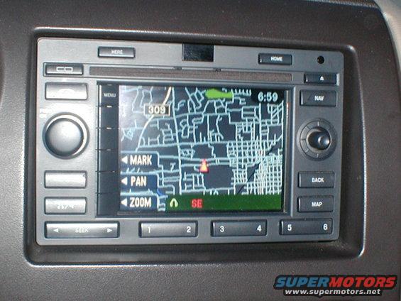 Car navigation screen displaying a map with street names and a red marker