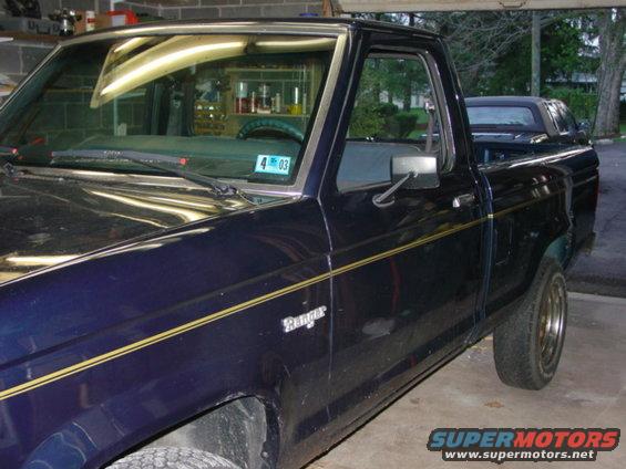 Dark blue 1985 Ford Ranger pickup truck parked in a garage, showing the driver's side front quarter panel and door