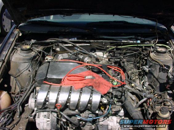 Engine bay with red rag and pliers on top of engine cover