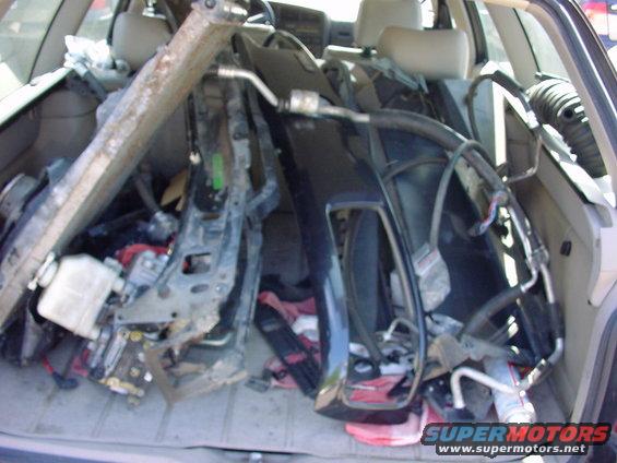 Car interior packed with car parts, including a radiator and bumper