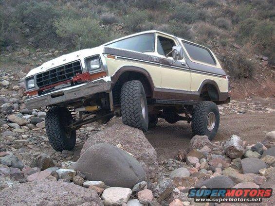 1978 Ford Bronco climbing over rocks on a trail