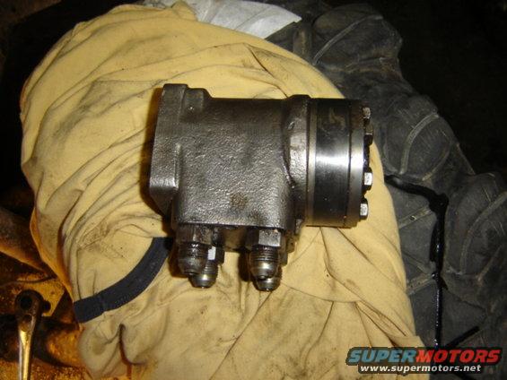 Close-up of a power steering gearbox with hydraulic fittings