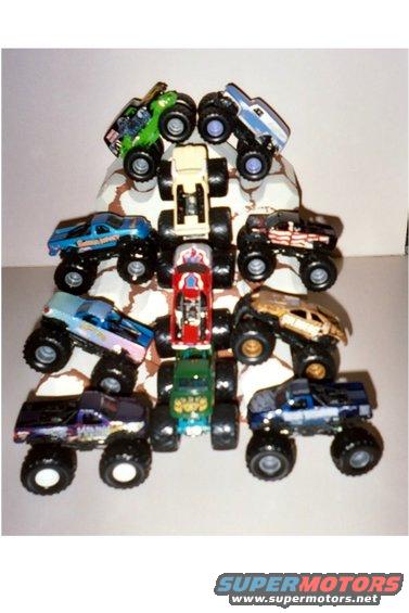 Collection of toy monster trucks stacked on rocks
