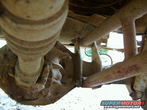 Close-up of a vehicle's rear axle and suspension parts, showing a differential housing and control arms