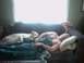1996 Ford Mustang - A man and his dog are asleep on a couch, with a bright window in the background.