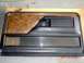 1979 Ford Bronco - A car door panel with faux wood grain trim and horizontal chrome accents is shown.