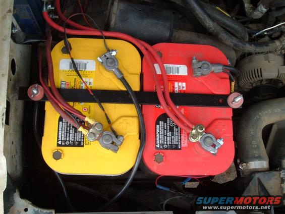 Dual yellow and red Optima batteries mounted in engine bay with red and black cables