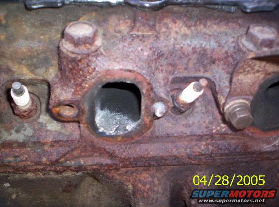 close-up of a rusty engine block with two spark plugs visible