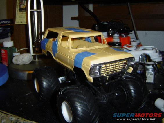 1979 Ford Bronco model kit with large tires, tan body, and blue masking tape
