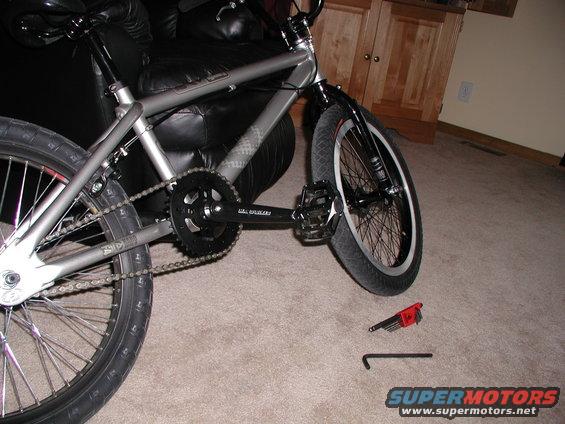 Silver bicycle frame and drivetrain with tools on carpet