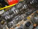 1986 Ford Mustang - Close-up of a heavily soiled engine block, showing internal components coated in dark, viscous sludge.