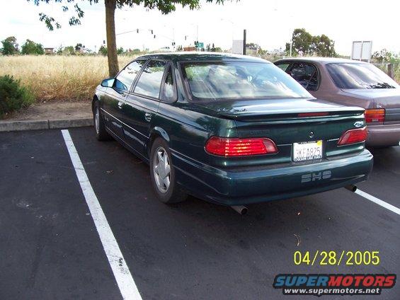 Dark green sedan parked in a lot, another car behind it. License plate reads 3KF1925