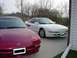 1993 Ford Probe - Two Ford Probes, one white and one red, are parked in a driveway.