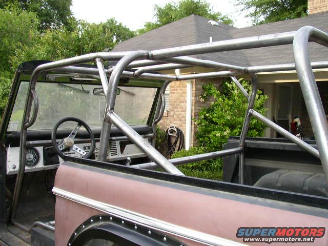 Interior view of a vehicle with a custom metal roll cage and steering wheel