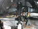 1994 Ford Bronco - Vehicle suspension components, including a coil spring and control arms, are visible while the vehicle is on jack stands.