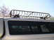 1999 Ford F-150 - A silver truck is equipped with a roof rack and a blue tie-down strap securing items.