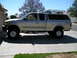 1999 Ford F-150 - Side view of a lifted 1999 Ford F-150 pickup truck equipped with a camper shell and roof rack.
