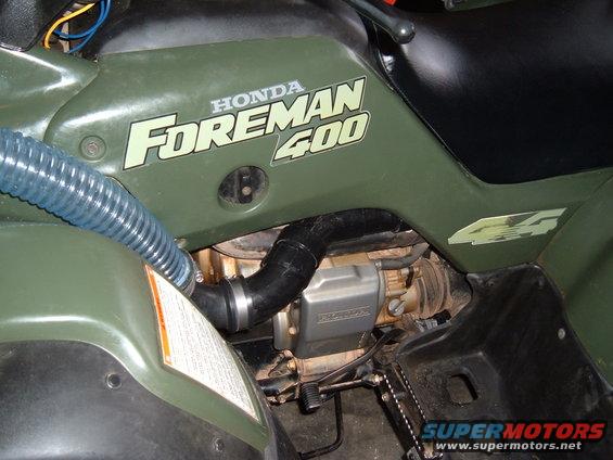Green Honda Foreman 400 ATV with visible engine components and blue intake hose