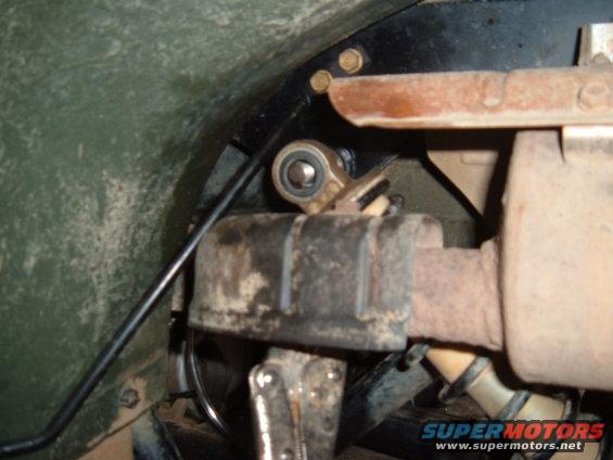 Close-up of exhaust pipe connection with a suspension linkage above it