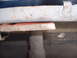 1978 Ford Mustang II - Close-up of vehicle undercarriage components, including an exhaust pipe and a red bracket.