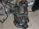 1976 Harley-Davidson Super Glide - A motorcycle transmission sits on a floor, surrounded by shop rags and tools, ready for maintenance.