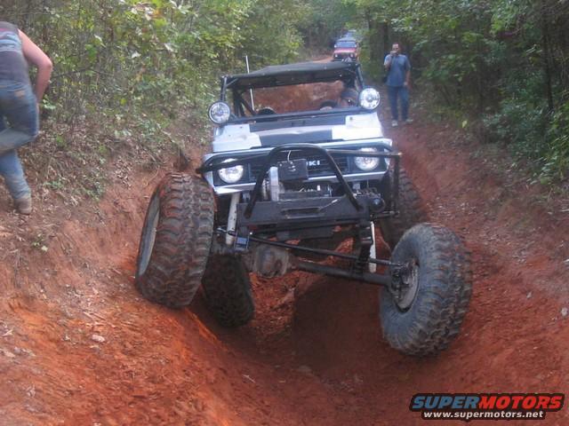 Modified off-road vehicle with large tires on a dirt trail
