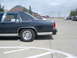 1990 Ford Crown Victoria - A dark blue sedan is parked in a lot, showing its rear quarter panel and chrome trim.