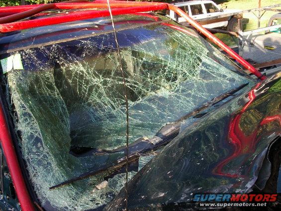 Cracked windshield and red roll cage on a dark colored vehicle
