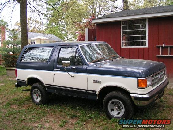 1987 Ford Bronco, two-tone blue and white, parked in a yard