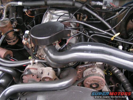Engine bay with hoses and engine components visible. Supermotors.net logo at bottom right