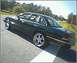 1992 Ford Crown Victoria - A dark green 1992 Ford Crown Victoria sedan is parked on the side of a road, viewed from the front three-quarter angle.