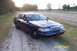 1998 Ford Crown Victoria - A dark blue Ford Crown Victoria Police Interceptor is parked on a dirt road with fields in the background.