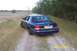 1998 Ford Crown Victoria - A dark blue 1998 Ford Crown Victoria is seen from the rear on a dirt road in a rural setting.