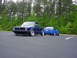 1998 Volkswagen Jetta - Two blue Volkswagens, a Golf Mk1 and a Jetta Mk3, are parked in a lot with trees in the background.